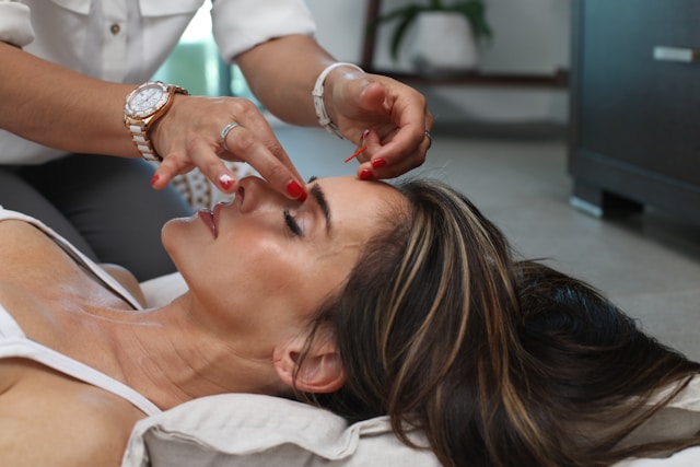 woman laying on table receiving a facial exam